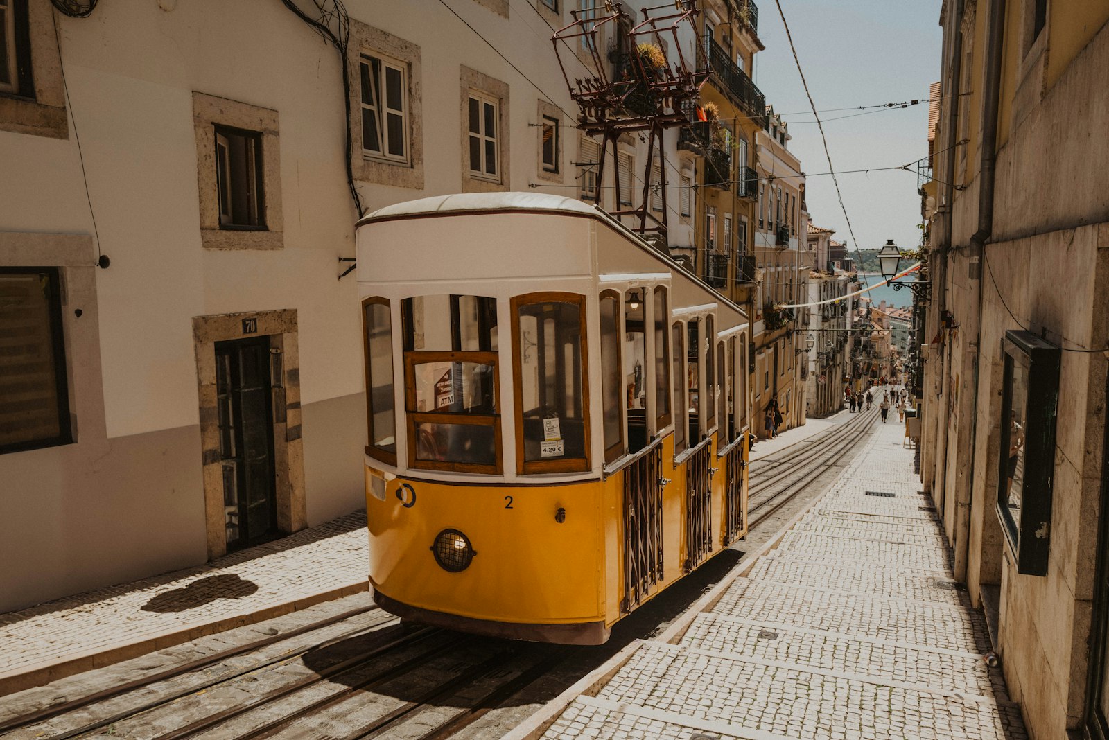 The yellow Bica funicular on its steep cobbled street in Lisbon
