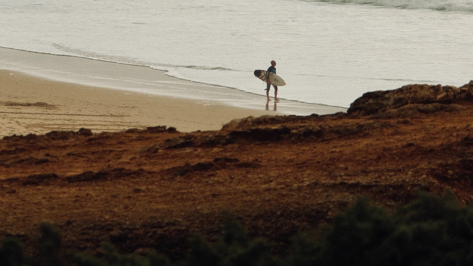 Surfer walking towards the Atlantic at Praia do Guincho